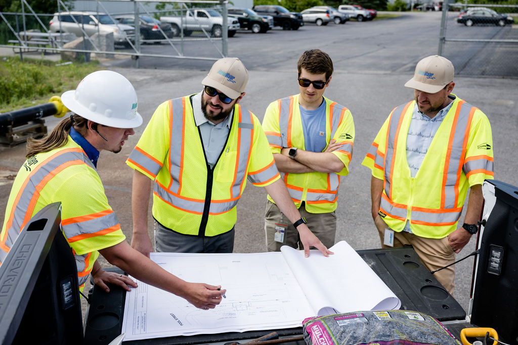 Maine Water employees on site looking at blue prints for a job