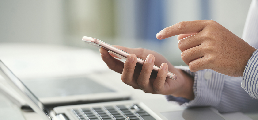 Person at a computer using calculator on their phone