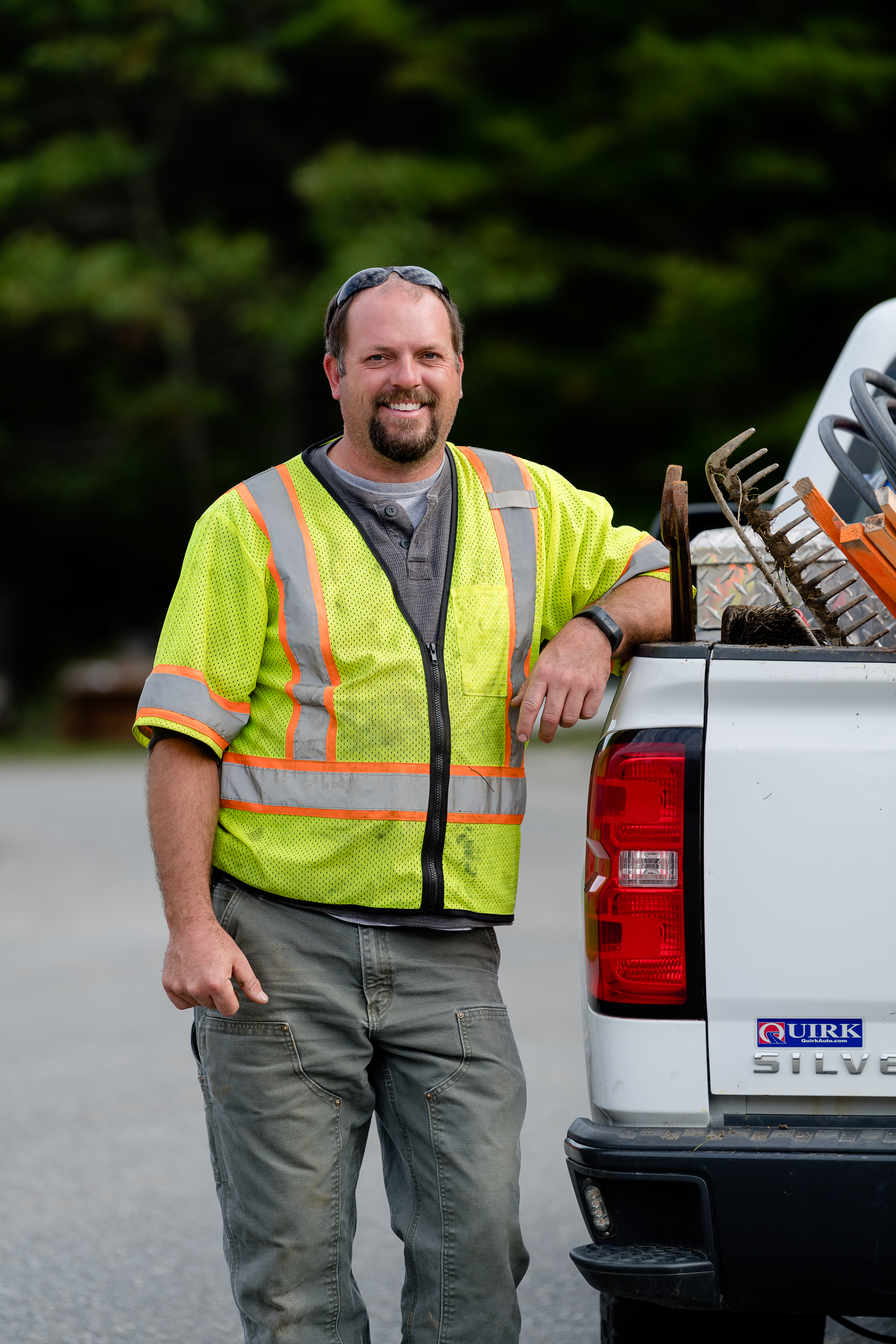 Maine Water employee leaning on his trucking smiling while looking at the camera